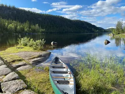 a canoe sitting on the shore of a lake at MYLLA - New cabin - Sauna - Hike - Bike - Canoe- Fishing in Jevnaker