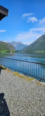 a body of water with mountains in the background at Lakeside apartment in Stryn