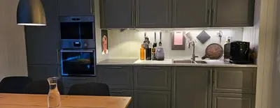 a kitchen with gray cabinets and a wooden table at Lakeside apartment in Stryn