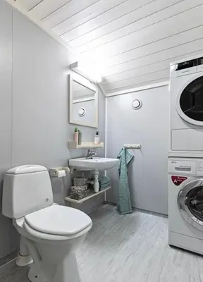 a bathroom with a toilet and a sink and a washing machine at Cabin with ski in-out in Sør-Fron