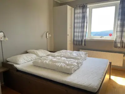 an unmade bed in a bedroom with a window at Stor Toppleilighet I Sentrum in Beitostøl