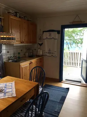 a kitchen with a wooden table and chairs and a window at Welcome to Dalborg, only 1,5 hours from Oslo