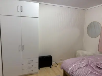 a bedroom with a bed and a large white cabinet at Apartment in Bergen in Bergen