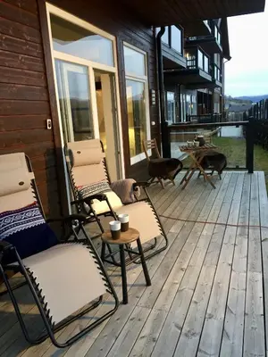 a deck with two chairs and two dogs on it at Stay in central Geilo, 3 bedrooms, linen and towels included in Geilo