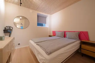 a bedroom with a large bed with a pink headboard at EasyStay Nesttun -Free Parking-Buss Nearby - in Bergen