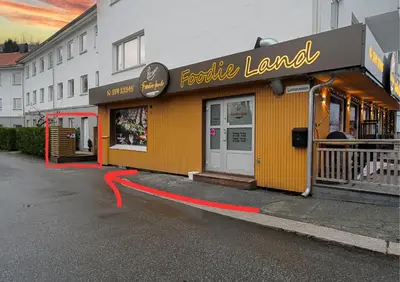 a yellow building with a red ribbon in front of it at EasyStay Nesttun -Free Parking-Buss Nearby - in Bergen
