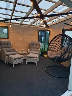 a screened in porch with chairs and a swing at Cabin at the end of Skardsøya towards the sea - boat in Bukta