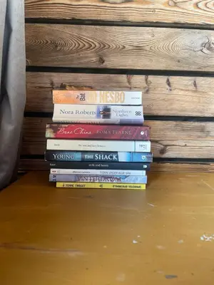 a stack of books sitting on the floor at Forest Hideaway With Scenic View in Fiskå