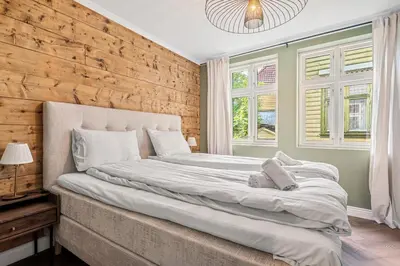 a bedroom with a large bed and two windows at The Townhouse Dream I No Expense Spared I NEW 2025 in Bergen