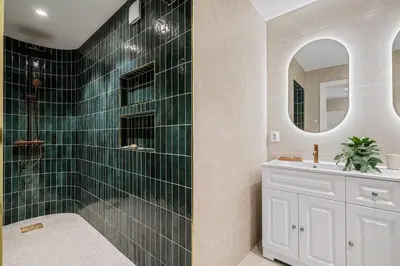 a bathroom with a green tiled shower and a sink at The Townhouse Dream I No Expense Spared I NEW 2025 in Bergen