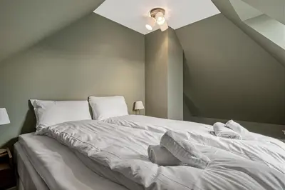 a bed with white sheets and pillows on it at The Townhouse Dream I No Expense Spared I NEW 2025 in Bergen