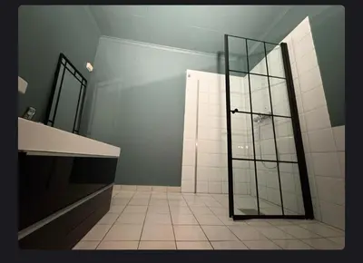 a bathroom with a shower with a glass door at House close to the beach with a view! in Ålesund