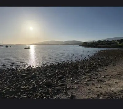 a beach with a boat in the water at House close to the beach with a view! in Ålesund