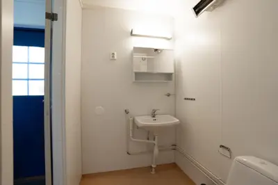 a white bathroom with a sink and a shower at Standard Rom in Fjæra