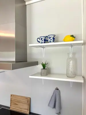 a kitchen with white shelves with bowls and a plant at House in Nordfjord, with 4 bedrooms in Nordfjordeid