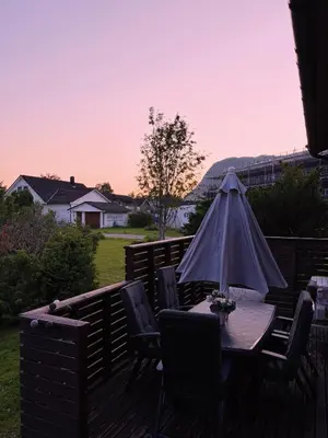 a table and chairs with an umbrella on a deck at House in Nordfjord, with 4 bedrooms in Nordfjordeid
