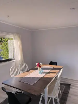 a dining room table with white chairs and a wooden table at House in Nordfjord, with 4 bedrooms in Nordfjordeid