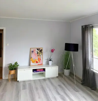 a living room with a white cabinet and flowers at House in Nordfjord, with 4 bedrooms in Nordfjordeid