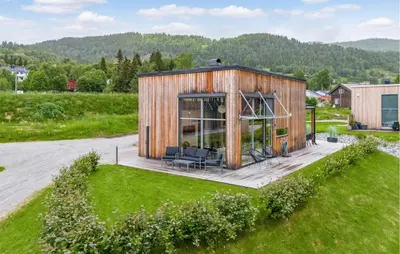 a wooden house with a deck in a field at Lovely Home In Ål With House Sea View in Ål