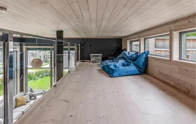 a living room with a blue couch on a wooden floor at Lovely Home In Ål With House Sea View in Ål