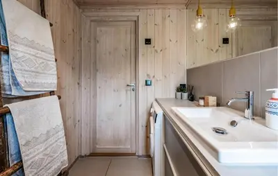 a small bathroom with a sink and a door at Lovely Home In Ål With House Sea View in Ål