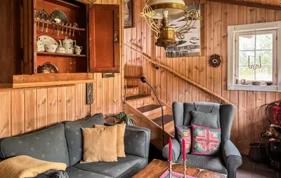 a living room with a leather couch and a window at Amazing Home In Tunhovd With Sauna in Tunhovd