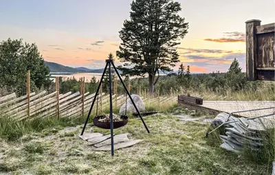 a swing in a field with a tree and a fence at Amazing Home In Tunhovd With Sauna in Tunhovd
