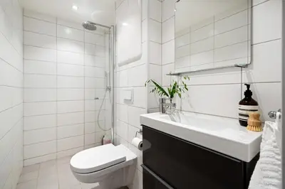 a white bathroom with a toilet and a sink at Modern apartment near bryggen - classic architecture in Bergen