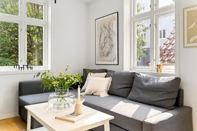a living room with a gray couch and a table at Modern apartment near bryggen - classic architecture in Bergen