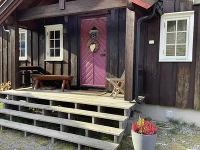 a purple door on the front of a wooden house at Skarvegløtt Ski in Ski out in Nesbyen
