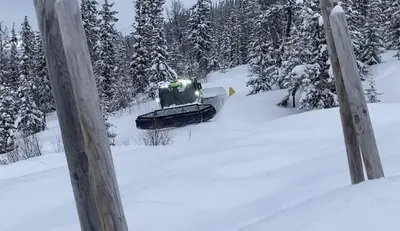 a snow plow is driving down a snow covered road at Skarvegløtt Ski in Ski out in Nesbyen