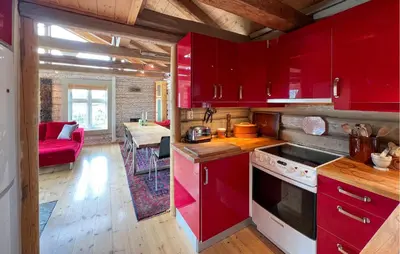 a kitchen with red cabinets and a living room at Beautiful Home In Røn With Sauna in Ron