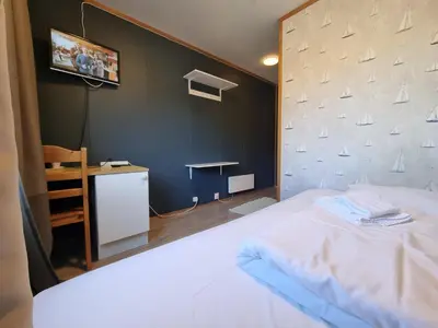 a bedroom with a white bed and a wall with sails at Atlanten Turistsenter in Kristiansund