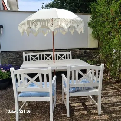 a white table with two chairs and an umbrella at Quiet home with garden in Bergen