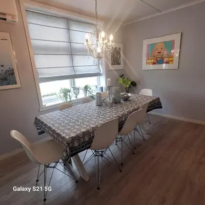 a dining room with a table with chairs and a chandelier at Quiet home with garden in Bergen
