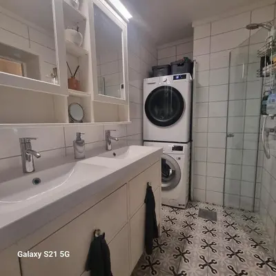 a bathroom with a washer and a washing machine at Quiet home with garden in Bergen