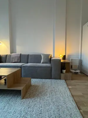 a living room with a blue couch and a coffee table at Oceanfront Stay, Large Balcony and Rooftop Access in Bergen