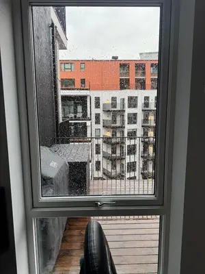 a window with a view of a city at Oceanfront Stay, Large Balcony and Rooftop Access in Bergen