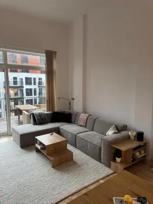 a living room with a gray couch and a large window at Oceanfront Stay, Large Balcony and Rooftop Access in Bergen