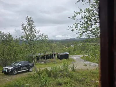 a black truck parked in a field next to a road at Utsikten in Geilo