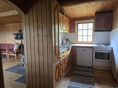 a kitchen with wooden cabinets and a stove top oven at Utsikten in Geilo
