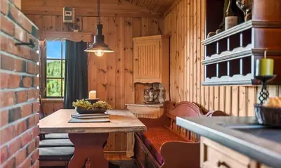 a kitchen with a table in a room with wooden walls at Authentic Secluded Mountain Cabin in Telemark with Panoramic Views