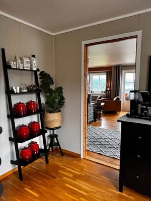 a living room with a door open to a kitchen at Kikays Hygge in Bysheim