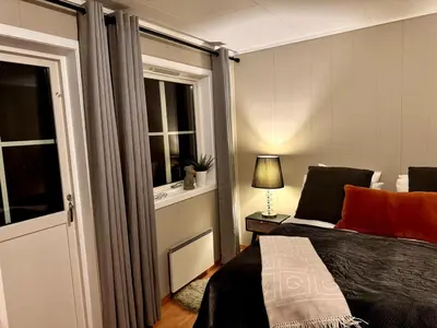 a bedroom with a bed and a lamp and a window at Kikays Hygge in Bysheim