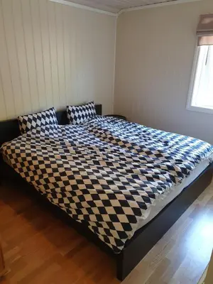 a bed in a room with a checkered bedspread at Spacious Wood Cabin 50 min from Bergen in Eikedalen