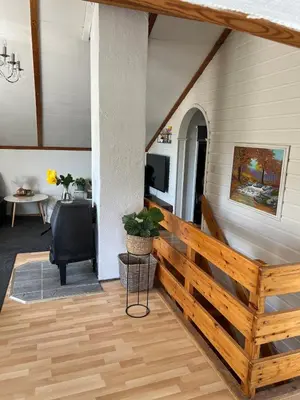 a living room with a wooden railing and a table at Studio in Os Near Bergen