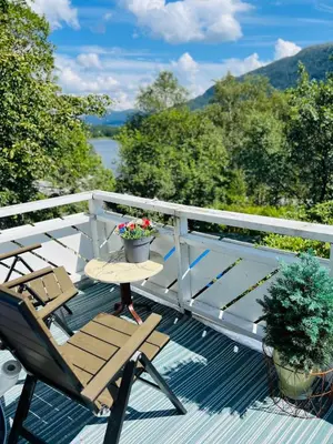 a deck with a table and a chair and a plant at Studio in Os Near Bergen