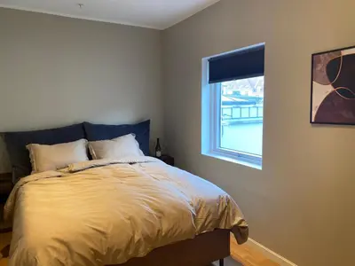 a bedroom with a bed and a window at Spacious Modern Apartment City center in Bergen