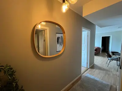 a hallway with a mirror on a wall at Spacious Modern Apartment City center in Bergen