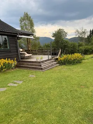 a house with a porch with a bench and flowers at Fantastic cabin in the woods & boat for rental or 2 days free boat on 7 days stay